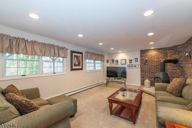 living room featuring baseboard heating, a wood stove, and carpet flooring