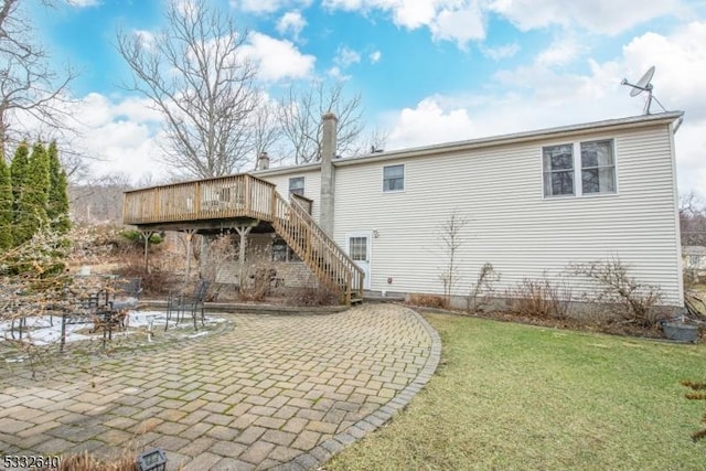 back of house featuring a lawn, a patio, and a wooden deck