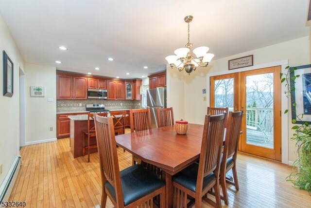 dining room featuring french doors, light hardwood / wood-style floors, an inviting chandelier, and a baseboard heating unit