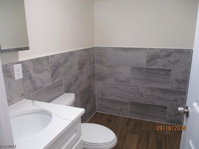 bathroom with vanity, tile walls, and toilet