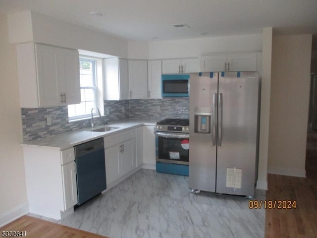 kitchen with white cabinets, backsplash, stainless steel appliances, and sink