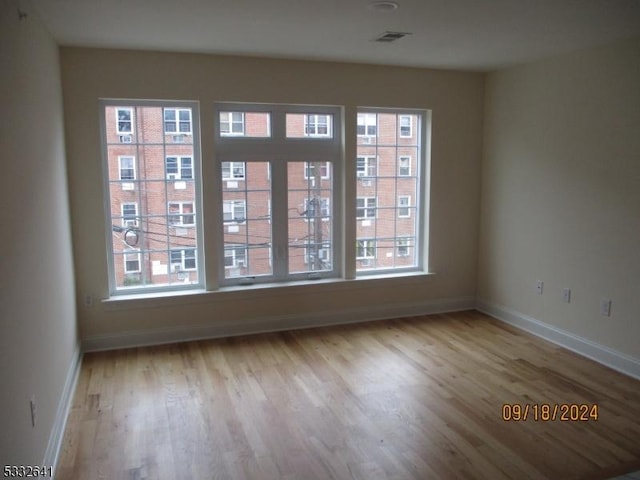 empty room with light hardwood / wood-style flooring