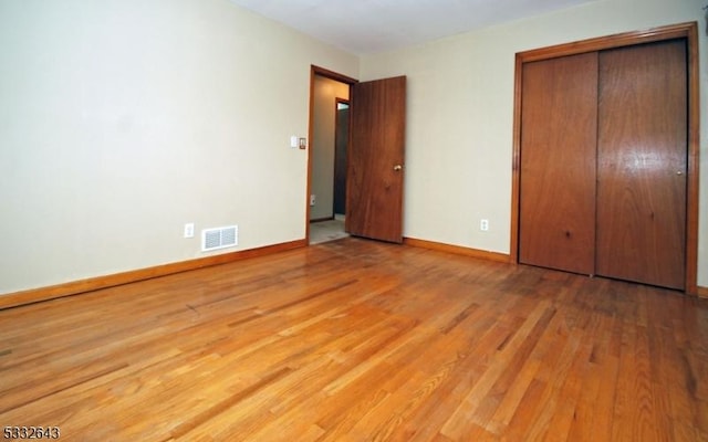 unfurnished bedroom featuring light hardwood / wood-style flooring and a closet