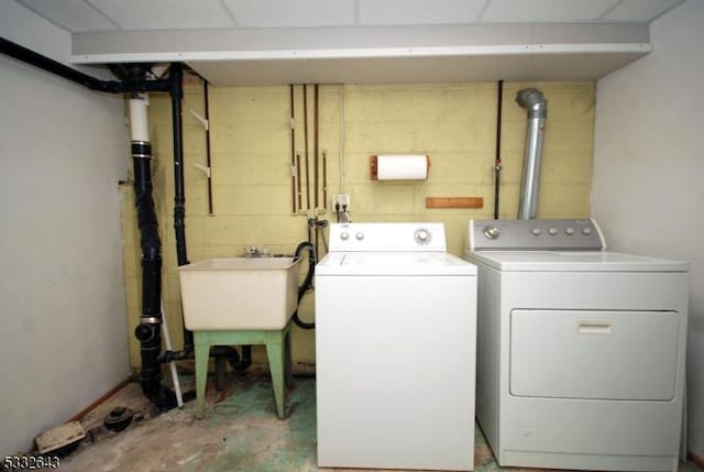 clothes washing area with independent washer and dryer and sink