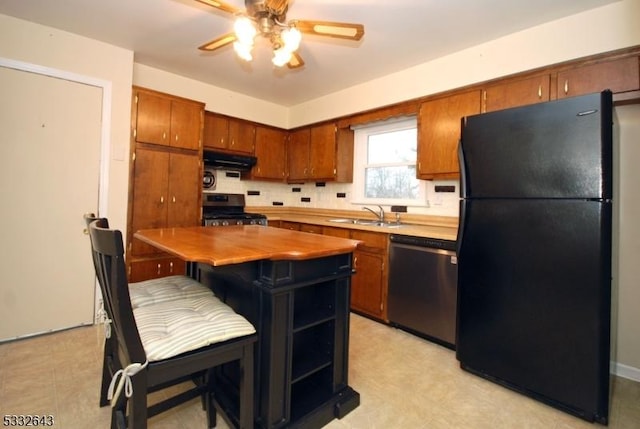 kitchen with sink, ceiling fan, decorative backsplash, appliances with stainless steel finishes, and a kitchen island