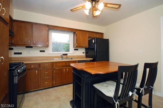 kitchen with black appliances, ceiling fan, sink, and tasteful backsplash