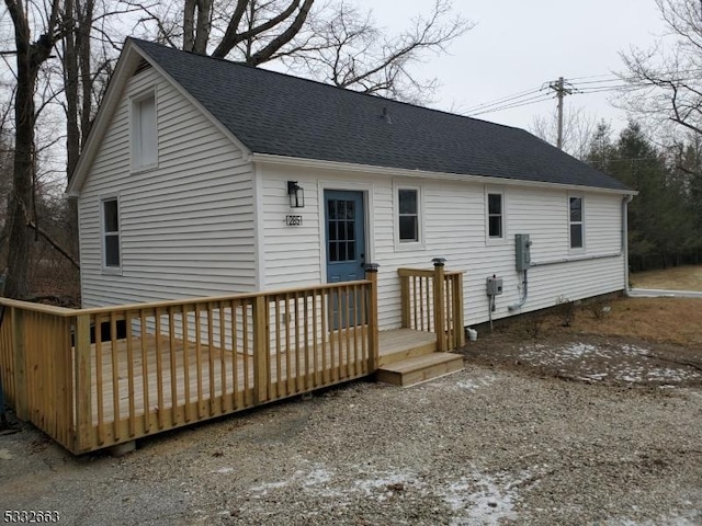 rear view of property featuring a wooden deck