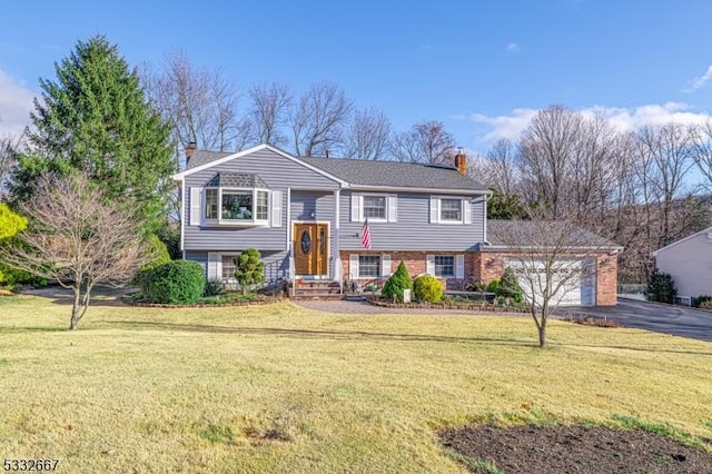 split foyer home with a front yard and a garage