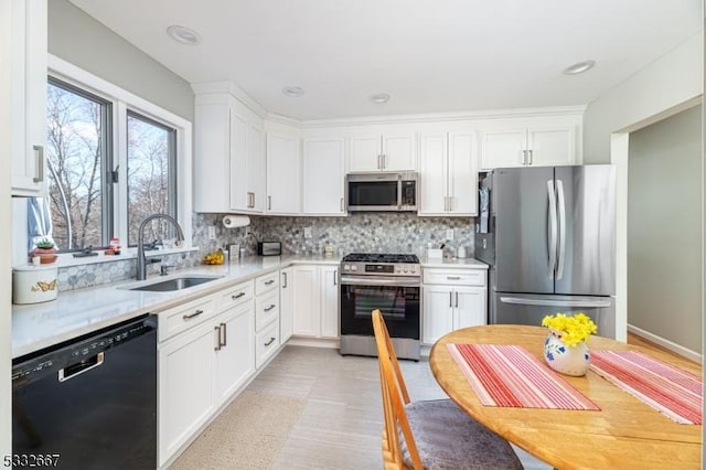 kitchen featuring sink, decorative backsplash, white cabinetry, and appliances with stainless steel finishes