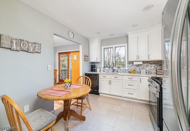 kitchen featuring stainless steel appliances, white cabinets, sink, and backsplash