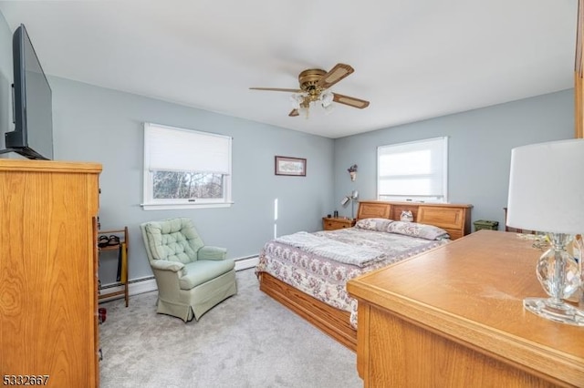 carpeted bedroom featuring a baseboard radiator, multiple windows, and ceiling fan