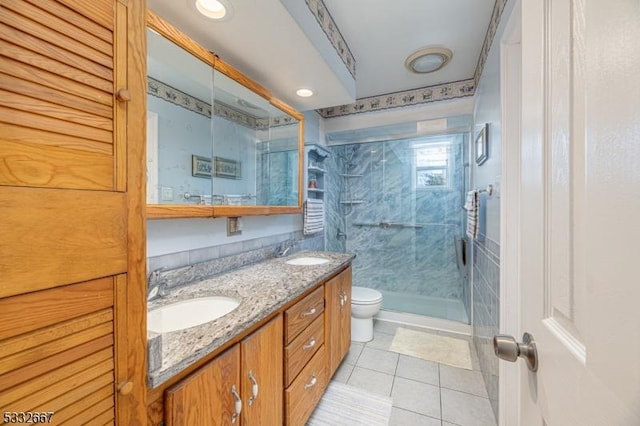 bathroom featuring toilet, tile patterned floors, walk in shower, and vanity