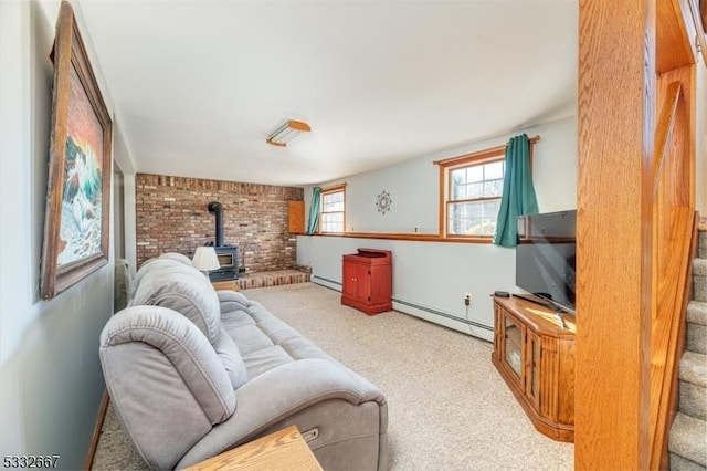 carpeted living room with brick wall, baseboard heating, and a wood stove