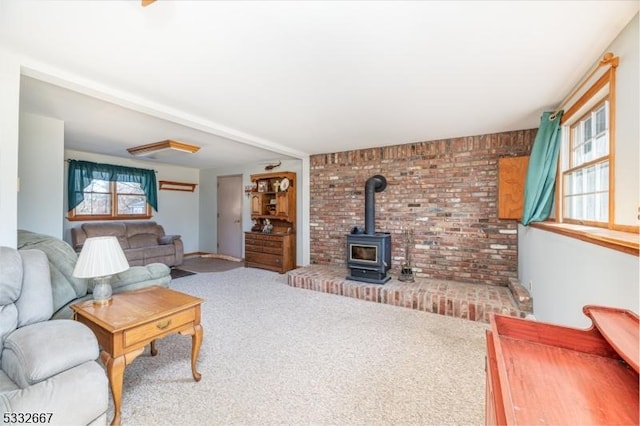 carpeted living room with a wood stove