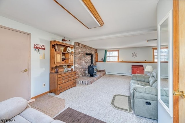 carpeted living room with a baseboard heating unit and a wood stove