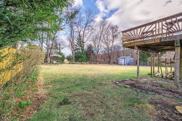 view of yard with a gazebo, a deck, and a shed