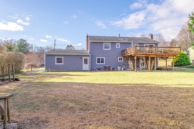 back of house featuring a deck and a lawn