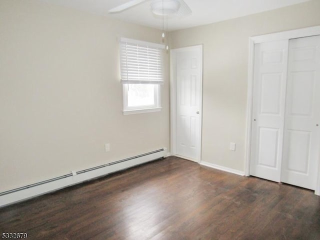 unfurnished bedroom featuring ceiling fan, a closet, dark hardwood / wood-style flooring, and a baseboard radiator