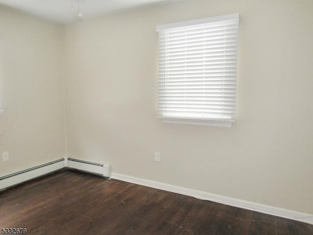 spare room with baseboard heating, dark hardwood / wood-style flooring, and a healthy amount of sunlight