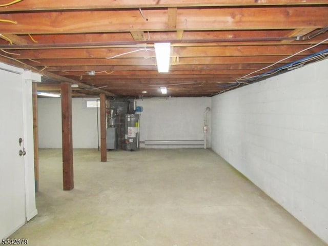 basement with baseboard heating, heating unit, and water heater