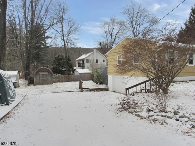 yard covered in snow featuring a storage shed