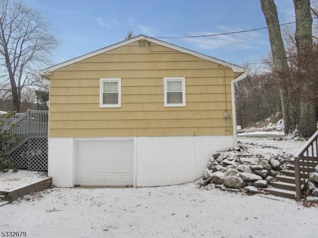 snow covered property featuring a garage