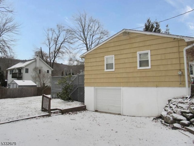 snow covered property featuring a garage