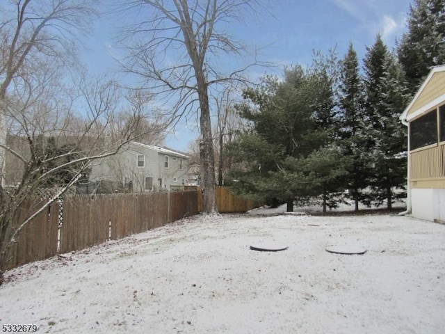 yard covered in snow featuring a sunroom