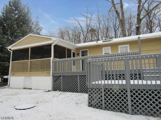 snow covered property with a deck