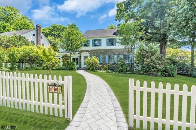 colonial inspired home with a front lawn