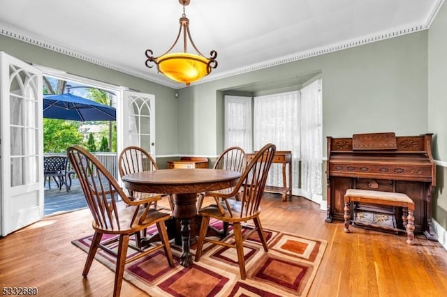 dining area with hardwood / wood-style flooring, crown molding, and french doors