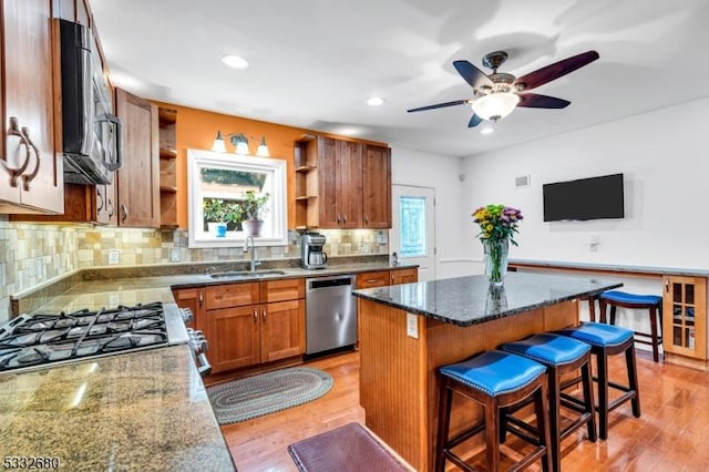 kitchen featuring plenty of natural light, sink, stainless steel appliances, and a kitchen island