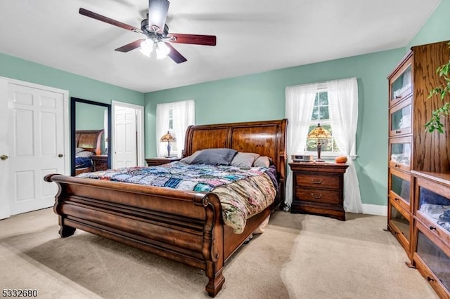 bedroom featuring ceiling fan, multiple windows, and light carpet