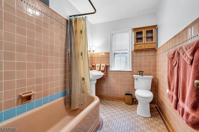 bathroom with toilet, shower / tub combo, tile walls, and tile patterned flooring