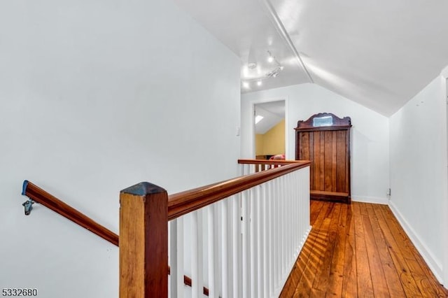 hall featuring lofted ceiling and hardwood / wood-style flooring