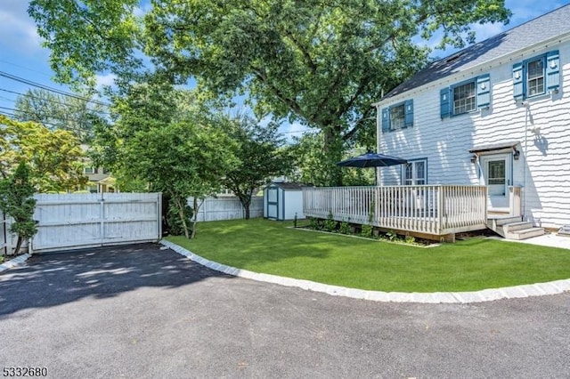 view of yard with a wooden deck and a storage unit