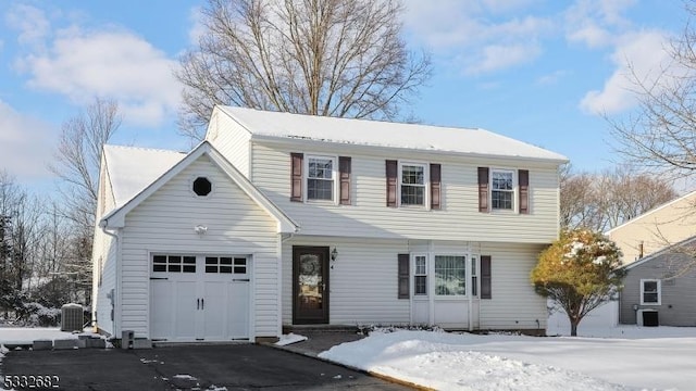 view of front of house with central air condition unit and a garage