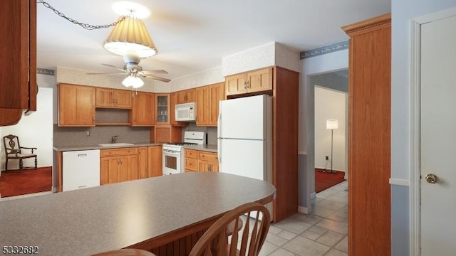 kitchen with white appliances, sink, backsplash, kitchen peninsula, and ceiling fan