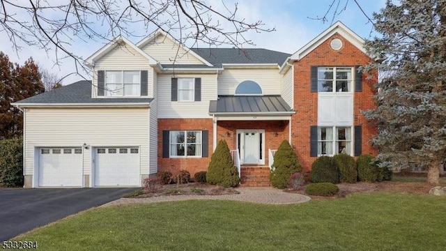 view of front facade featuring driveway, an attached garage, a front lawn, and brick siding