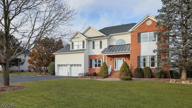 view of front of home featuring driveway, brick siding, and a front yard