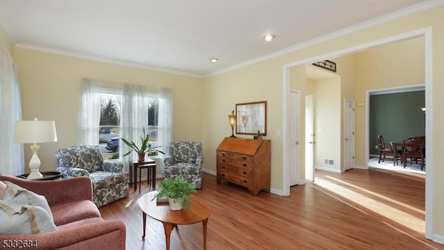 living area with baseboards, visible vents, wood finished floors, crown molding, and recessed lighting