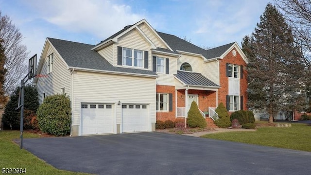 traditional-style house with an attached garage, driveway, a front lawn, and brick siding