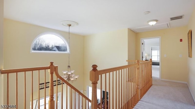 corridor featuring visible vents, light colored carpet, an upstairs landing, and attic access