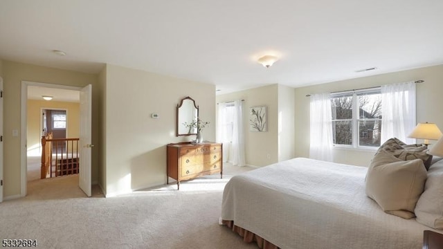 bedroom featuring visible vents and light colored carpet