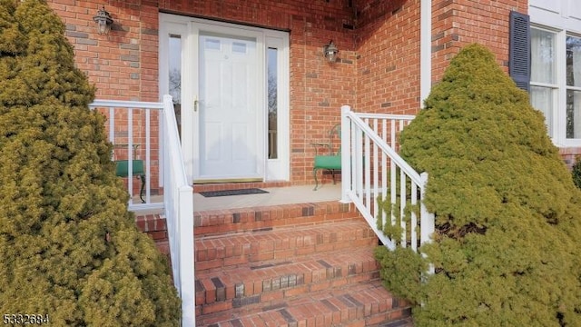 doorway to property featuring brick siding