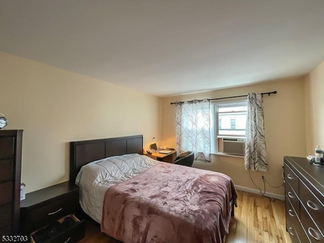 bedroom featuring light wood-type flooring and cooling unit