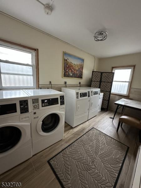 clothes washing area with light hardwood / wood-style floors and independent washer and dryer