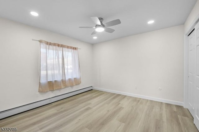 empty room featuring ceiling fan, light hardwood / wood-style flooring, and a baseboard radiator