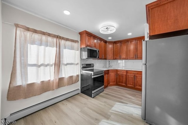 kitchen featuring sink, baseboard heating, appliances with stainless steel finishes, and plenty of natural light