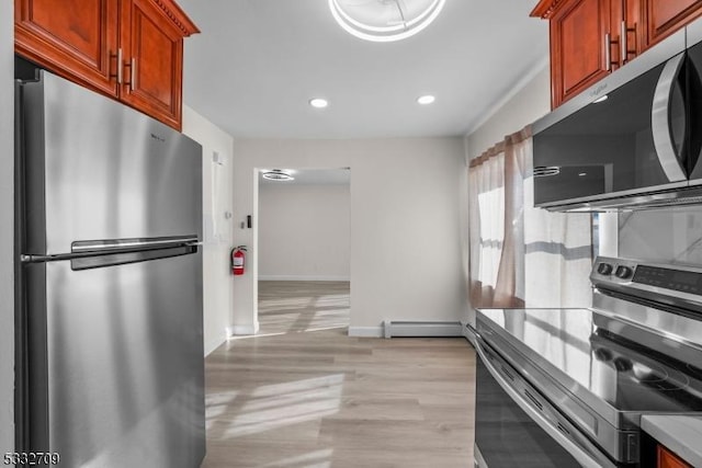 kitchen featuring stainless steel appliances, a baseboard radiator, and light hardwood / wood-style flooring